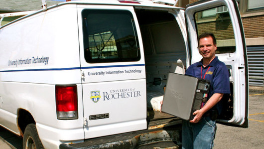 man unloading computer equipment from van