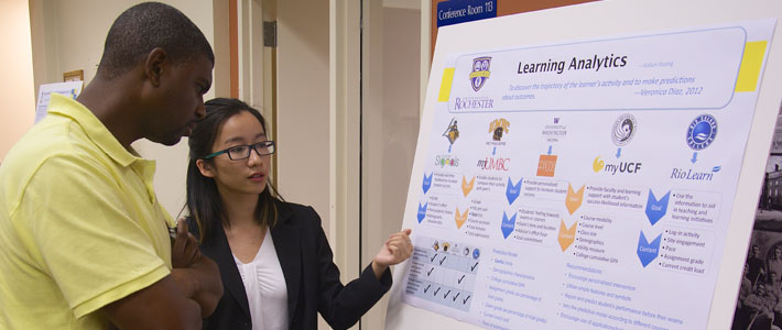 Students present their work at a poster session in August.